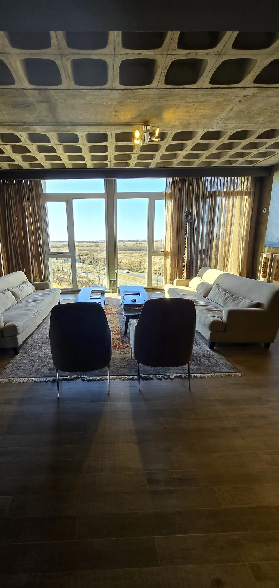Living de la oficina Dracma con vista panorámica a los campos de Córdoba