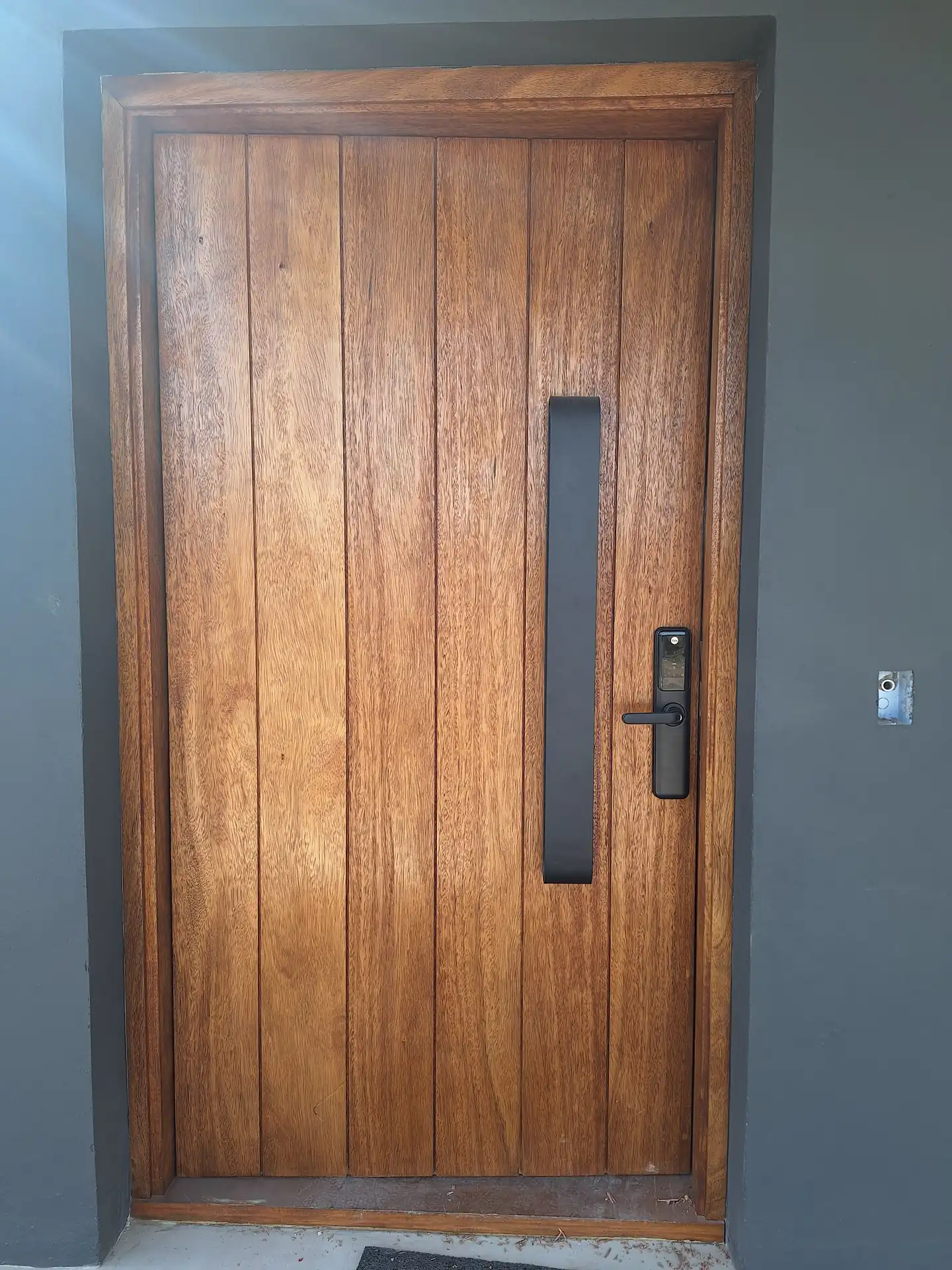 Cerradura digital con teclado y lector integrados, instalada en una puerta de madera maciza
