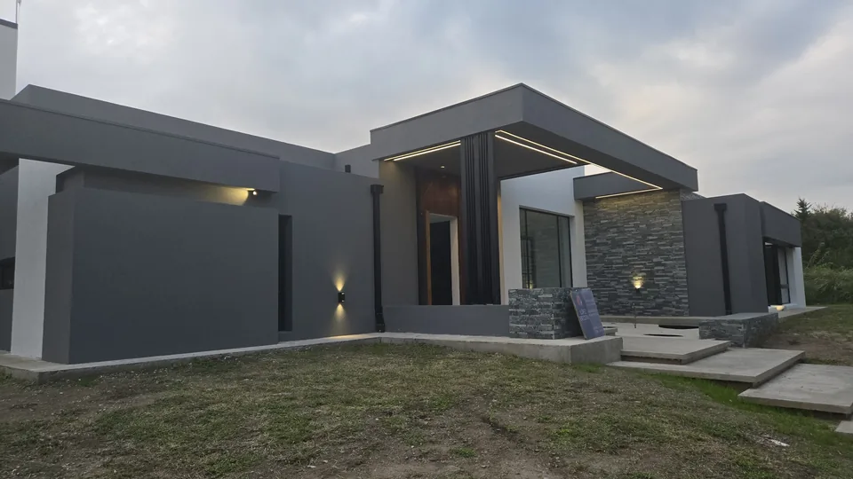 Fachada de vivienda al atardecer con iluminación exterior integrada